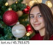 Улыбающаяся девушка возле новогодней елки. Стоковое AI-изображение, AI-художник Римма Тельнова / Фотобанк Лори