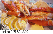 Red king crab legs with fresh lemon slices. Стоковое видео, видеограф Андрей Армягов / Фотобанк Лори