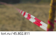 A close-up of a red and white striped tape, commonly used for cordoning off areas. The tape stretches into the distance, creating a sense of perspective. The background is blurred. Стоковое видео, видеограф Воловодов Владимир / Фотобанк Лори