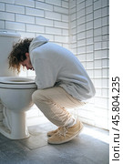 Young man vomiting in toilet suffering from food poisoning or hangover. Стоковое AI-изображение, AI-художник Юрий Поздников / Фотобанк Лори