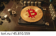 Gold Bit Coin BTC coins on the motherboard. Bitcoin is a worldwide cryptocurrency and digital payment system called the first decentralized digital currency. Стоковое видео, видеограф Андрей Армягов / Фотобанк Лори