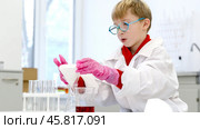 a student in a chemical laboratory conducts chemical sweats with chemical elements in. Стоковое фото, фотограф Igor Skripachev / Фотобанк Лори