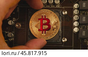 Gold Bit Coin BTC coins on the motherboard. Bitcoin is a worldwide cryptocurrency and digital payment system called the first decentralized digital currency. Стоковое видео, видеограф Андрей Армягов / Фотобанк Лори