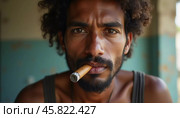 A young man residing in Cuba smokes a cigar while looking directly at the viewer, showcasing a unique hairstyle and a calm demeanor in a vibrant environment. Generative AI. Стоковое AI-изображение, AI-художник Юлия Петровская / Фотобанк Лори