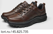 Dark brown leather lace-up running shoes with low tops, thick soles. The laces and black rubber outsole. Sporty look. Men to wear during outdoor activities, hiking. Brown shoes. Trendy Male Boots Pair. Стоковое AI-видео, аниматор Марина Демидюк / Фотобанк Лори