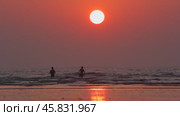 Beautiful sunset on the ocean. Silhouettes of people on the shore. Стоковое видео, видеограф Виктор Тихонов / Фотобанк Лори