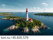 Aerial view of landscape of archipelago of islands with lighthouse in north sea, skyline at blue sky background. Amazing natural wild scenery view of Scandinavian nature concept. Copy ad text space. Стоковое AI-изображение, AI-художник Aleksandr Golubev / Фотобанк Лори