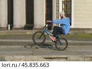 BMX in the Moscow park. Young man doing trick on the bike in the summer day. Extreme sports is very popular among youth. 2019. Редакционное фото, фотограф YuryKara / Фотобанк Лори