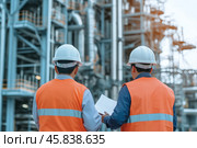 Engineers in Safety Gear Conducting Comprehensive Assessments of Industrial Facilities. Civil employees team review project plan at industrial facility factory building. Construction Industry. Outdoor. Стоковое AI-изображение, AI-художник Марина Демидюк / Фотобанк Лори