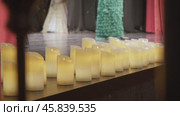 A lot of electric candles, which simulate fire, stand and glow on the stage during a theatrical performance. Стоковое видео, видеограф Strunov David / Фотобанк Лори