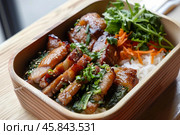 Delicious teriyaki chicken bento box with rice and vegetables. Стоковое AI-изображение, AI-художник Иван Рябоконь / Фотобанк Лори