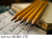 Five sharpened pencils lying on spiral notebook with handwriting. Стоковое AI-изображение, AI-художник Иван Рябоконь / Фотобанк Лори