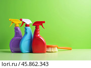 Assortment of household chemicals. Set of three multicolored bottles with nozzles - sprayers on green background. Copy space. AI generative. Стоковое AI-изображение, AI-художник Роман Дзюбало / Фотобанк Лори