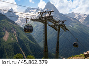 View of the supports of the Dombay ski resort cable car on the background of the Caucasus Mountains on a summer day, Karachay-Cherkessia, Russia. Стоковое фото, фотограф Ula Ulachka / Фотобанк Лори