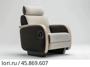 Modern recliner armchair with integrated headrest and adjustable features on plain background. Стоковое AI-изображение, AI-художник Иван Рябоконь / Фотобанк Лори