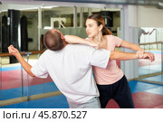 Young woman practicing elbow blow with wristlock to opponent in gym. Стоковое фото, фотограф Яков Филимонов / Фотобанк Лори