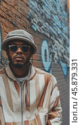 Stylish man posing against graffiti wall. Стоковое AI-видео, аниматор Юрий Поздников / Фотобанк Лори