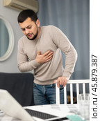 Young man having heart pain and feeling unwell at home. Стоковое фото, фотограф Яков Филимонов / Фотобанк Лори