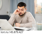 Man rubs tired eyes with his hands after a long work at laptop at home. Стоковое фото, фотограф Яков Филимонов / Фотобанк Лори