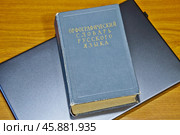 Старый большой орфографический словарь русского языка лежит на современном ноутбуке. Концепция ограничения использования заимствованных слов. Стоковое фото, фотограф Владимир Устенко / Фотобанк Лори
