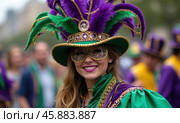 Colorful Mardi Gras Celebration With a Costumed Participant Smiling During a Lively Parade in a Vibrant Street Setting. Стоковое AI-изображение, AI-художник Sergey Grishin / Фотобанк Лори