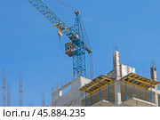 Строящееся высотное здание и подъемный кран на фоне голубого неба. Building crane and building under construction against blue sky. Стоковое фото, фотограф Татьяна Д / Фотобанк Лори