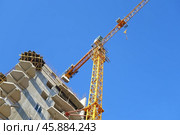 Строящееся высотное здание и подъемный кран на фоне голубого неба. Building crane and building under construction against blue sky. Стоковое фото, фотограф Татьяна Д / Фотобанк Лори
