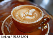 Latte art coffee in brown ceramic cup on matching saucer. Стоковое AI-изображение, AI-художник Иван Рябоконь / Фотобанк Лори
