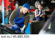 Professional mechanic man in uniform repairing car in auto repair garage. Стоковое фото, фотограф Яков Филимонов / Фотобанк Лори