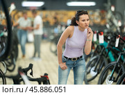 Avid female cyclist exploring variety of bicycles in store. Стоковое фото, фотограф Яков Филимонов / Фотобанк Лори