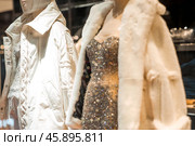 An elegant showcase of an expensive luxury store with stylish mannequins in clothes and evening lighting. The concept of shopping and sales. Стоковое фото, фотограф Photojuli / Фотобанк Лори