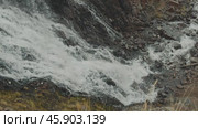 A cascade of waterfalls cascades down, crashing against dark rocks. Редакционное видео, видеограф Strunov David / Фотобанк Лори