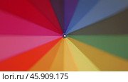 A multi-colored rainbow umbrella rotates. Стоковое видео, видеограф Михаил Коханчиков / Фотобанк Лори