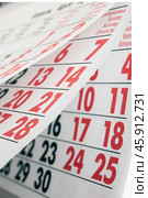 Переворачивание листов календаря с черными и красными цифрами / Flipping of calendar sheets with black and red numbers. Стоковое фото, фотограф Петроченко Мария Петровна / Фотобанк Лори