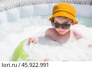 It's a hot day. A cute boy in sunglasses and a panama hat swims on a circle in a foam pool. The concept of summer holidays with children. Стоковое фото, фотограф Photojuli / Фотобанк Лори