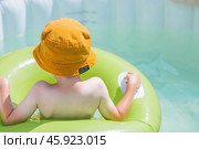 It's a hot day. A cute boy in sunglasses and a panama hat swims on a circle in a foam pool. The concept of summer holidays with children. Стоковое фото, фотограф Photojuli / Фотобанк Лори