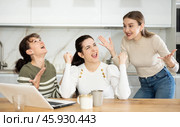 Three happy middle-aged woman expressing joy for winning in the kitchen. Стоковое фото, фотограф Яков Филимонов / Фотобанк Лори