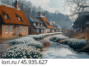 Beautiful blooms of spring snowdrops, Galanthus nivalis, by the side of the river that runs through the village with thatched cottages in the background. Стоковое AI-изображение, AI-художник Ирина Михайличенко / Фотобанк Лори