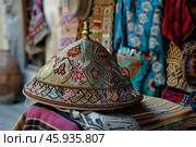 Traditional uzbek skullcap resting on a fabric displaying intricate embroidery. Стоковое AI-изображение, AI-художник Иван Рябоконь / Фотобанк Лори