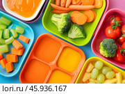Colorful lunch boxes filled with healthy food for kids. Стоковое AI-изображение, AI-художник Иван Рябоконь / Фотобанк Лори
