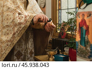 A priest prepares candle for a child's baptism. Стоковое фото, фотограф Irina Kuchugurina/Gaudy / Фотобанк Лори