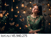 Portrait of a beautiful girl in a green dress among many suspended light bulbs and butterflies fluttering around her. Daydreaming. A magical atmosphere. Стоковое AI-изображение, AI-художник Photojuli / Фотобанк Лори
