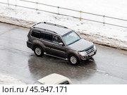 Car Mitsubishi Pajero moving on the street. SUV vehicle driving along wet slippery street in city with blurred background. Редакционное фото, фотограф Константин Григорьев / Фотобанк Лори