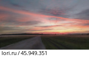 Вечерний закат в поле, с деревенской дорогой и туманом на полях. Evening sunset in the field, with a village road and fog on the fields. Стоковое видео, видеограф Наталья Пеньшина / Фотобанк Лори