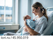 A woman in a hospital bed in the maternity ward. Mom has a newborn baby in her arms. Pregnancy and childbirth. Стоковое AI-изображение, AI-художник Photojuli / Фотобанк Лори