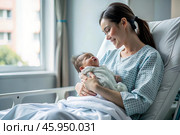 A woman in a hospital bed in the maternity ward. Mom has a newborn baby in her arms. Pregnancy and childbirth. Стоковое AI-изображение, AI-художник Photojuli / Фотобанк Лори