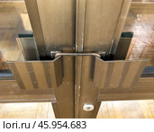 Двустворчатые двери заблокированы от открытия с помощью металлической скобы продетой в ручки. Стоковое фото, фотограф Вячеслав Палес / Фотобанк Лори