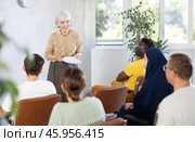 Elderly woman giving lecture to international adult group. Стоковое фото, фотограф Яков Филимонов / Фотобанк Лори