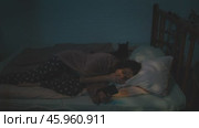 Insomniac weary woman using smartphone lying awake in bed with cat. Стоковое видео, видеограф Маргарита Кирьякова / Фотобанк Лори