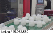 Transparent plastic cups stacked on a conveyor belt in an industrial production line. Manufacturing and packaging process concept. Стоковое видео, видеограф Андрей Журавлев / Фотобанк Лори